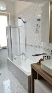 een witte badkamer met een bad en een wastafel bij Mira Mila in Massa Lubrense