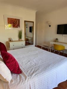 a bedroom with a large white bed with red pillows at Vila Graciosa - Tranquility Oasis in Lagos