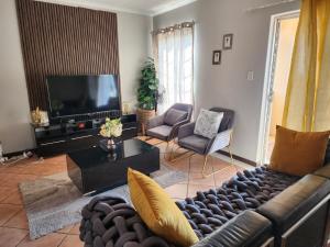 ein Wohnzimmer mit einem Sofa und einem TV in der Unterkunft The lion Sands Apartment in Pretoria