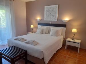 a bedroom with a large white bed with two lamps at Aurora Sol in Luz