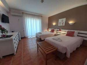 a hotel room with two beds and a television at Aurora Sol in Luz