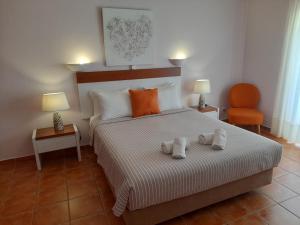 a bedroom with a bed with two towels on it at Aurora Sol in Luz