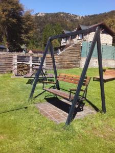 a swing set in a park with a bench at Cabañas Kay Hue in San Carlos de Bariloche