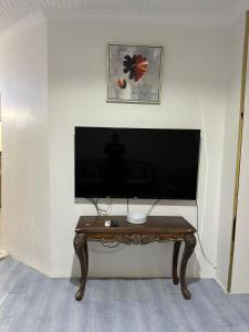 sala de estar con mesa y TV de pantalla plana en دار ورد 8, en Medina