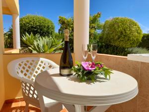 a table with a bottle of wine and two glasses at Aurora Sol in Luz