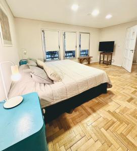 Dormitorio con cama, escritorio y TV en Jaque Mate Hostel en Mendoza