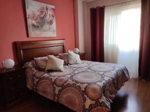 a bedroom with a bed with a flowered blanket and a window at Casa Capi in La Orotava