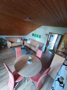 a living room with a wooden table and pink chairs at Günther Fernschild in Trochtelfingen