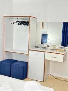 een kamer met een bureau en een blauwe kruk bij Eleni Guest House in Sarandë