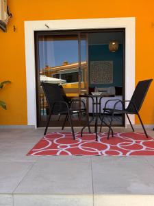 a patio with a table and chairs on a rug at Casa Concha - Peaceful and Relaxing in Lagos