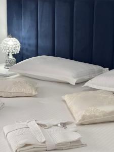 2 letti con lenzuola e cuscini bianchi su un letto di Eleni Guest House a Sarandë
