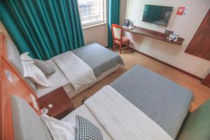 Cette chambre comprend deux lits et une télévision. dans l'établissement Zhangjiajie Tianmen Mountain Aribadi Inn, à Zhangjiajie