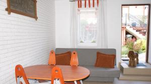 a dog sitting on a couch next to a table at Domek pod różą in Krasnobród