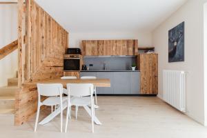 a kitchen with a table and white chairs at PINZOLO MOUNTAIN LODGE in Pinzolo