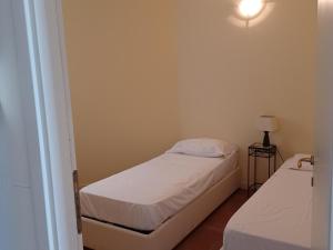 a small room with two beds and a lamp at Apartment by Lake Maggiore with Stunning View in Oggebbio