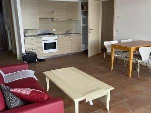 a living room with a table and a kitchen at Apartment by Lake Maggiore with Stunning View in Oggebbio