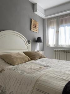 sypialnia z dużym łóżkiem z białym zagłówkiem w obiekcie Apartamento Zurbarán w mieście Irún