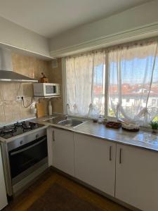 een keuken met een wastafel, een fornuis en een raam bij Apartamento Zurbarán in Irún