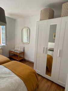 Apartamento Zurbarán في إرون: غرفة نوم مع خزانة بيضاء كبيرة مع مرآة