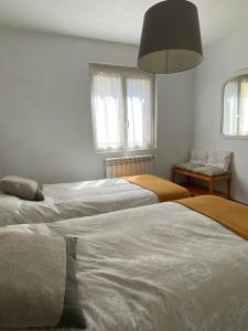 a bedroom with three beds and a pendant light at Apartamento Zurbarán in Irún