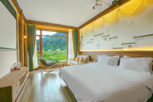 um quarto com uma cama grande e uma janela grande em Pure House em Zhangjiajie