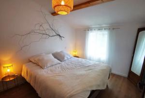 um quarto com uma cama com um ramo na parede em Sérénity, entre Terre et Océan, classée 3 étoiles em Corme-Écluse