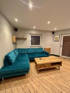 a living room with a blue couch and a coffee table at Beach front apartment in Edinburgh