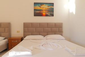 a bed in a bedroom with a picture on the wall at Vila Dura in Ksamil
