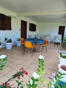 un patio con mesa, sillas y flores en chez arlette, en Petit-Bourg