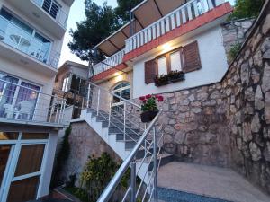 Una escalera que conduce a un edificio con flores. en Aparthotel Villa Maja, en (( Gornji Sušanj ))