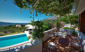 uma casa com uma piscina e um pátio com cadeiras em Villa Casa Belvedere near Dubrovnik em Gruda