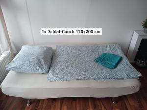 uma cama branca com duas almofadas em cima em Helle FeWo am Waldrand - mit Pool und Sauna em Freyung