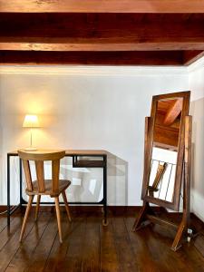 una scrivania con sedia, lampada e specchio di Affittacamere Medusa a Firenze