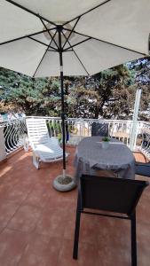 patio con ombrellone, tavolo e sedie di Apartman Giulitta a Porat