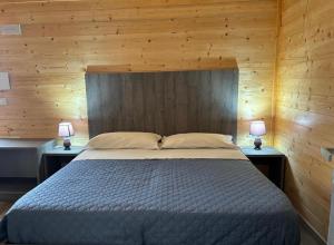a bedroom with a large bed with two lamps on tables at Lido Tirreno beach in Campora San Giovanni