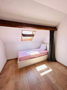 a small bedroom with a bed and a window at Lit Style Dortoir dans un Maison in Bezons