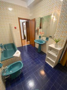 ein Badezimmer mit einer blauen Badewanne und einem Waschbecken in der Unterkunft The Shamrock House in Palazzolo Acreide