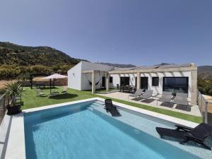 a swimming pool in front of a house at Recently built Holiday Home El Limonar in La Herradura