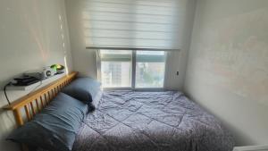 sypialnia z łóżkiem i oknem w obiekcie 서울의 야경이 멋진 옐로우 하우스 w Seulu
