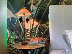 a table with books and a lamp and a plant at Designerwohnung nahe Stuttgart Messe und Flughafen in Filderstadt