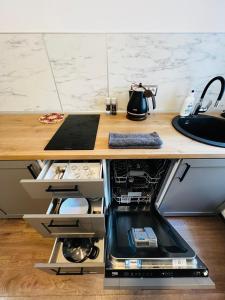 an office desk with an open drawer with a tea kettle at CHERRY apartment in Riga +21 photos