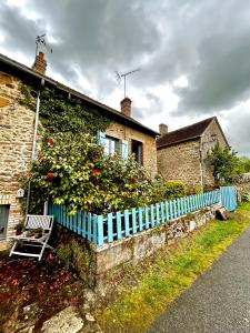 a blue fence in front of a house with a plant at La Cassine bis - Havre de paix à Saint Ceneri in Moulins-le-Carbonnel