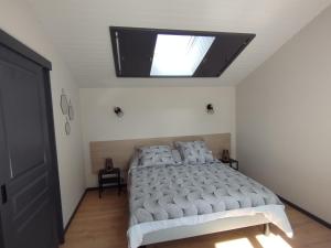 1 dormitorio con 1 cama con tragaluz en GITE O Petits OIGNONS, en Les Herbiers