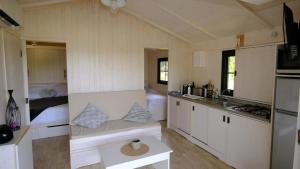 a small kitchen with a couch in a tiny house at Les Cabanes de Lara in Ménesplet