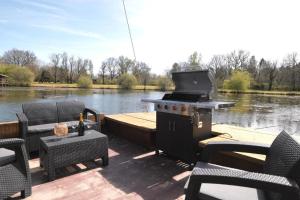 a dock with a grill and chairs on the water at Les Cabanes de Lara in Ménesplet