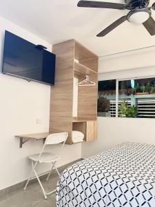 1 dormitorio con 1 cama, escritorio y TV en Cal Bed & Breakfast Ibague, en Ibagué