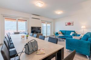 a living room with a table and a blue couch at VILLA DEI VENTI NORTH by Curtiaffitti in Pianello Del Lario