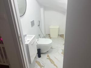 La salle de bains blanche est pourvue de toilettes et d'un lavabo. dans l'établissement Villa Myria, à Paphos