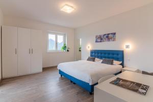 a bedroom with a blue bed and a living room at VILLA DEI VENTI NORTH by Curtiaffitti in Pianello Del Lario +127 photos