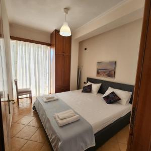 une chambre avec un grand lit avec deux serviettes dessus dans l'établissement SunSea apartment, à Saranda